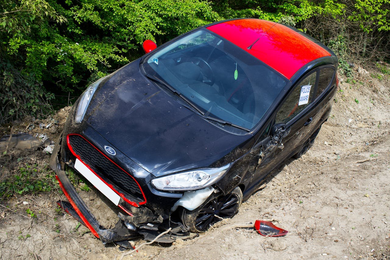 about-us A black and red Ford Fiesta lies abandoned and damaged off-road in Welwyn Garden City, UK.