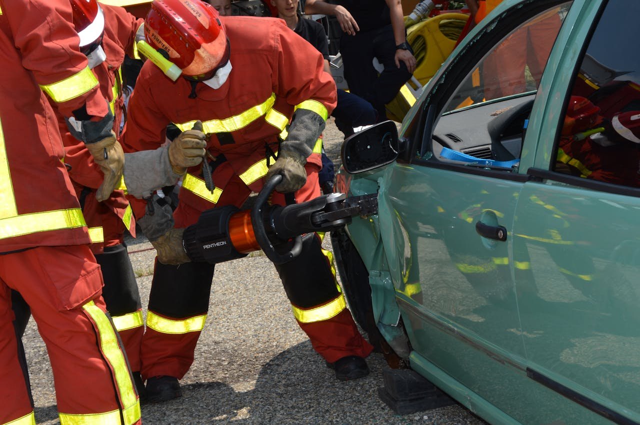 our-story Firefighters demonstrate rescue techniques using a hydraulic cutter at a car crash practice session.